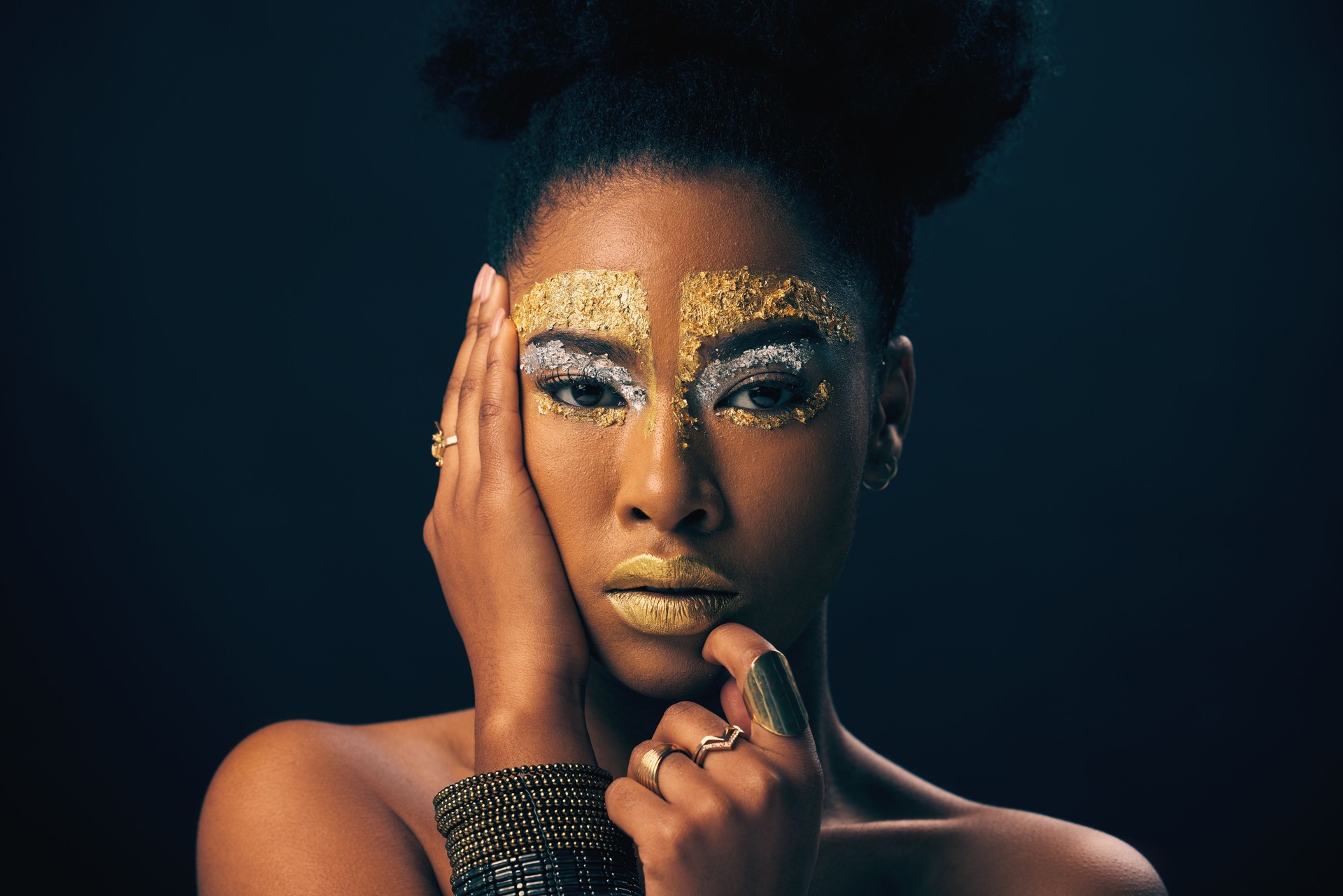 Makeup, gold and fantasy with portrait of black woman in studio for luxury, cosmetics or African pride. Natural, creative and goddess with female model on background for queen, bronze or glamour art